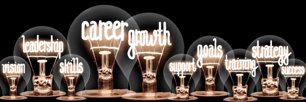 Photo of light bulbs with shining fibers in shapes of Career Growth, Goals, Skills, Strategy and Training concept related words isolated on black background